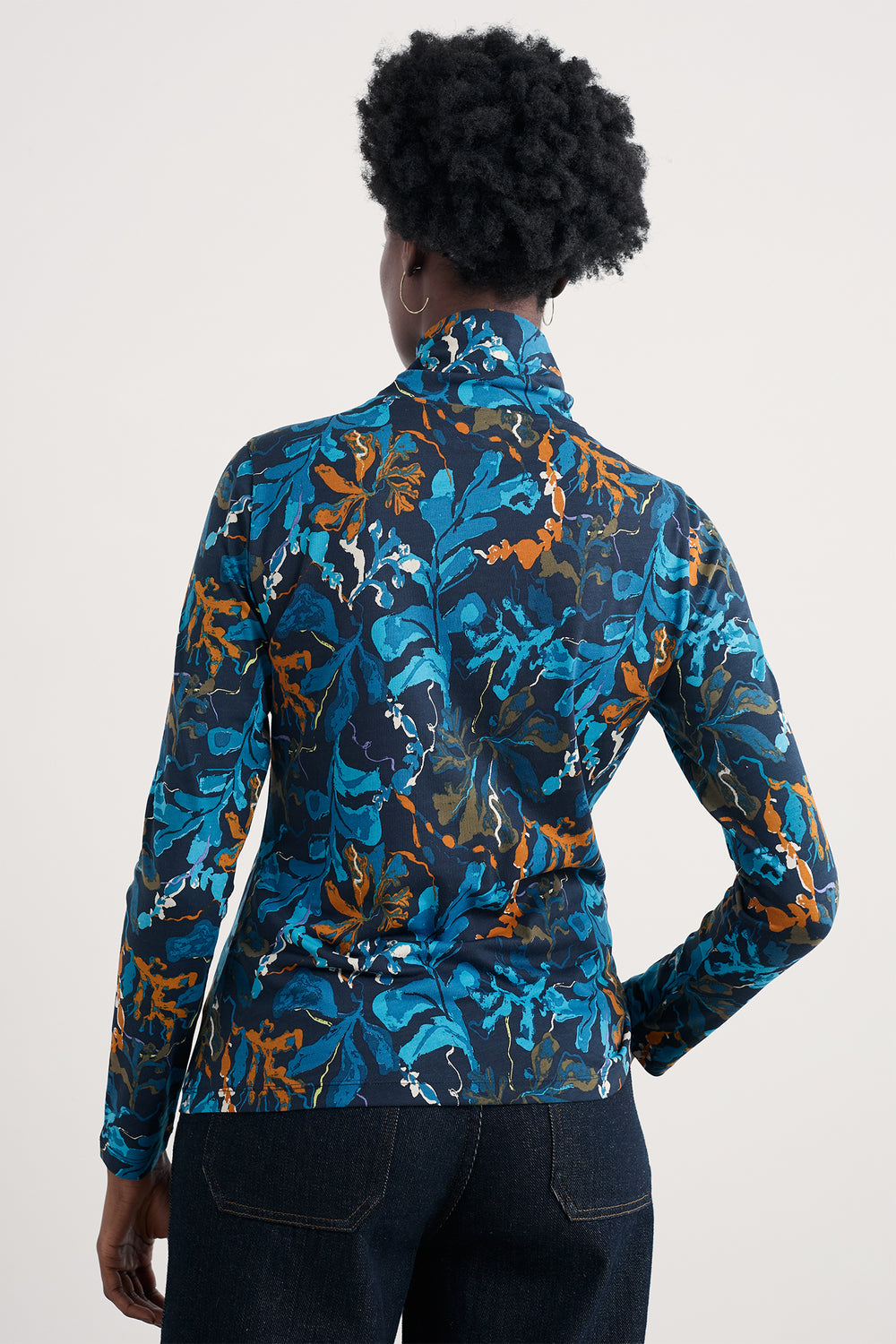 Person wearing a blue and orange floral patterned jacket on a white background