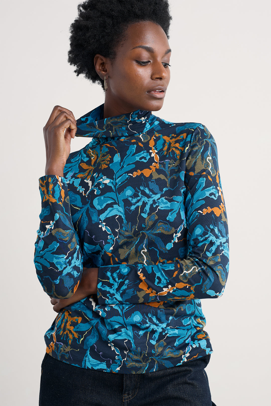 Woman wearing a blue and orange floral patterned jacket on a light background