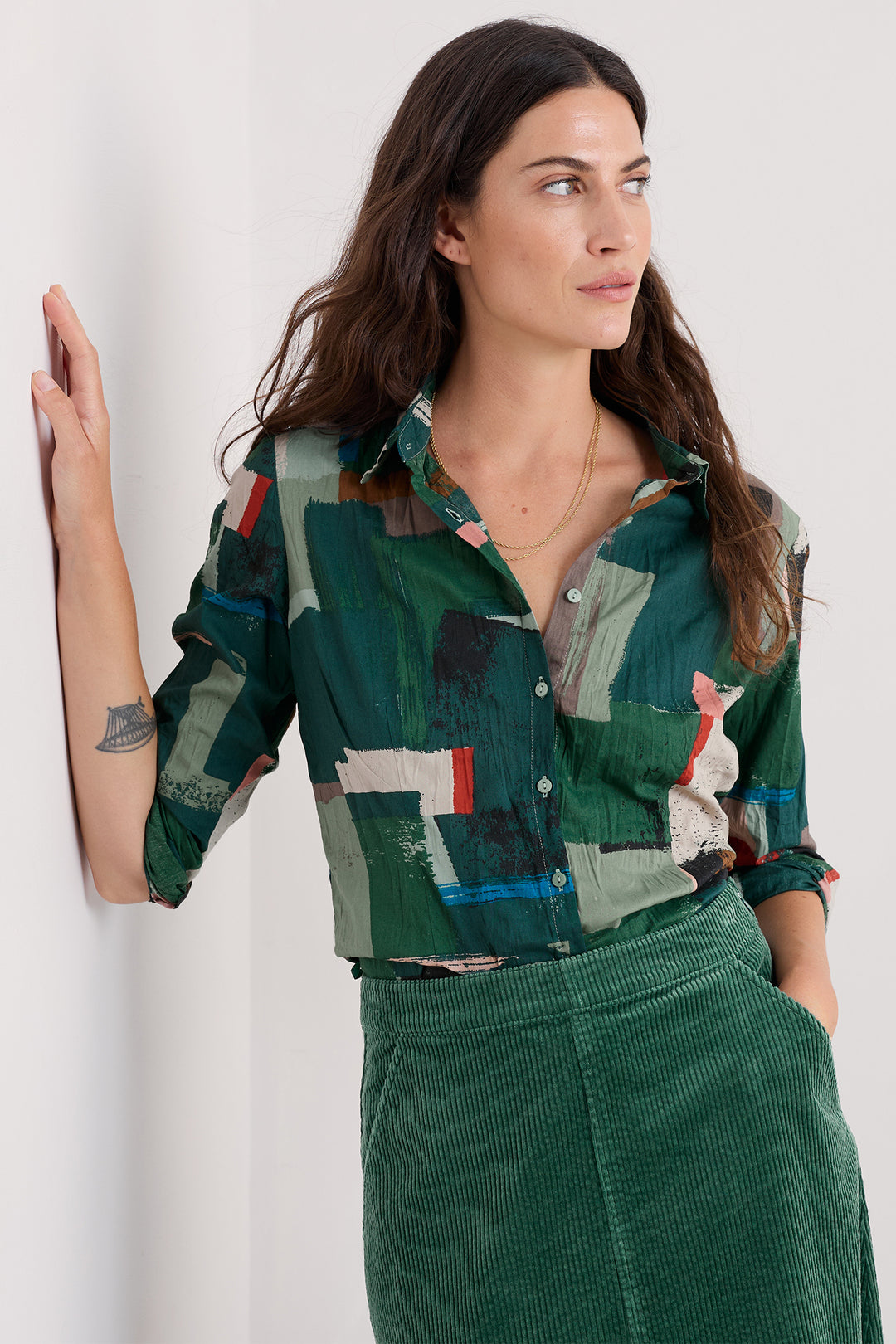 Person wearing a colorful geometric-patterned shirt on a white background