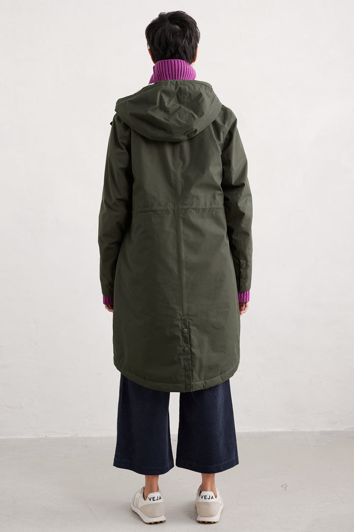 Person wearing a long green coat with a hood on a white background