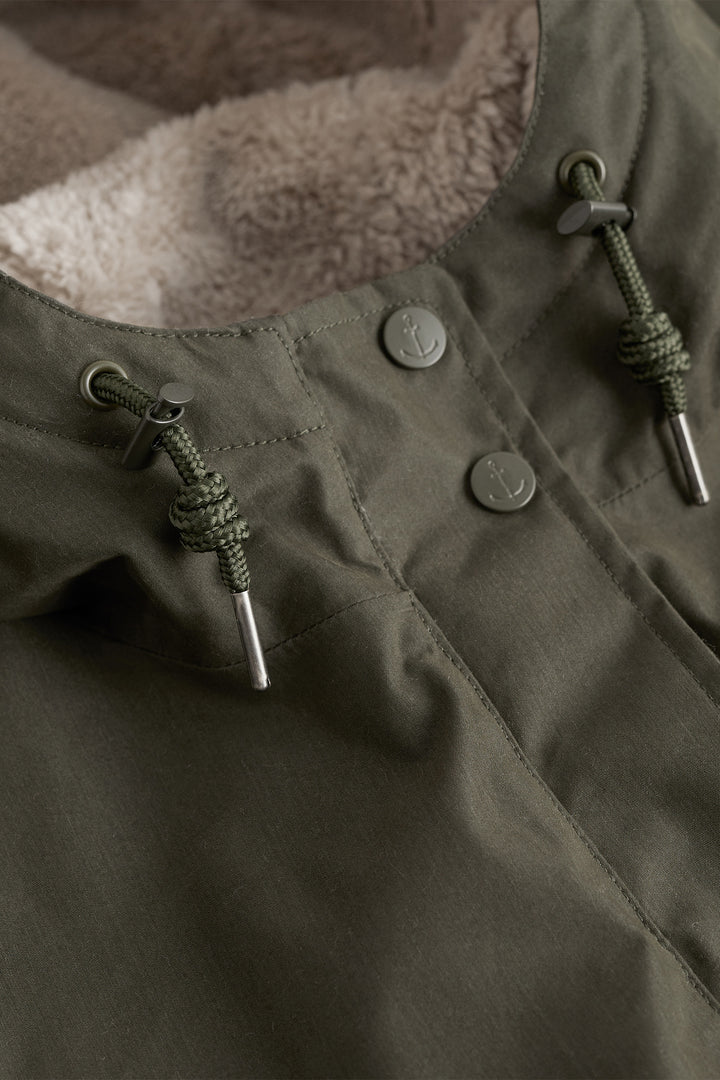 Close-up of a green jacket with buttons and a textured interior
