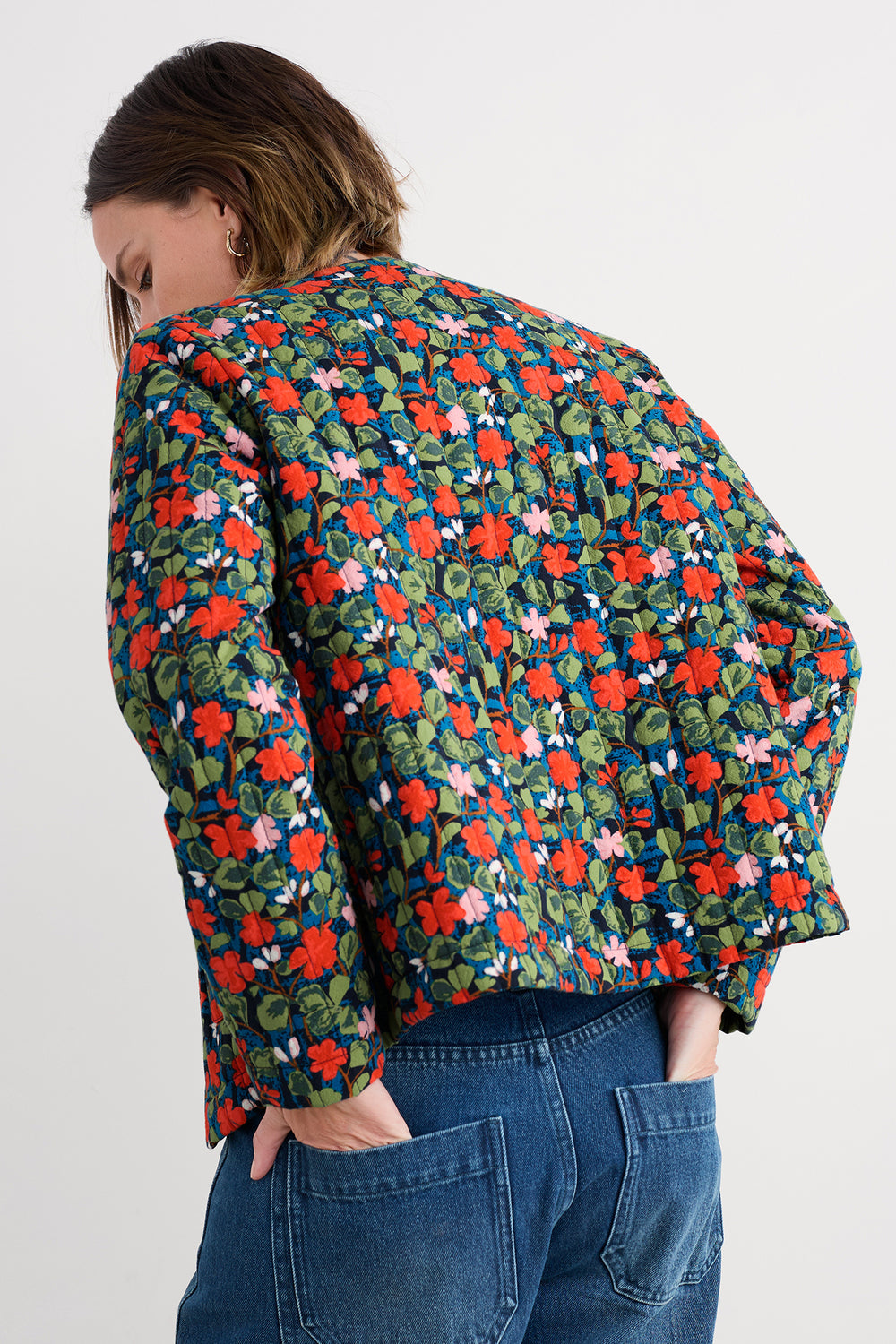 Person wearing a colorful floral jacket on a white background