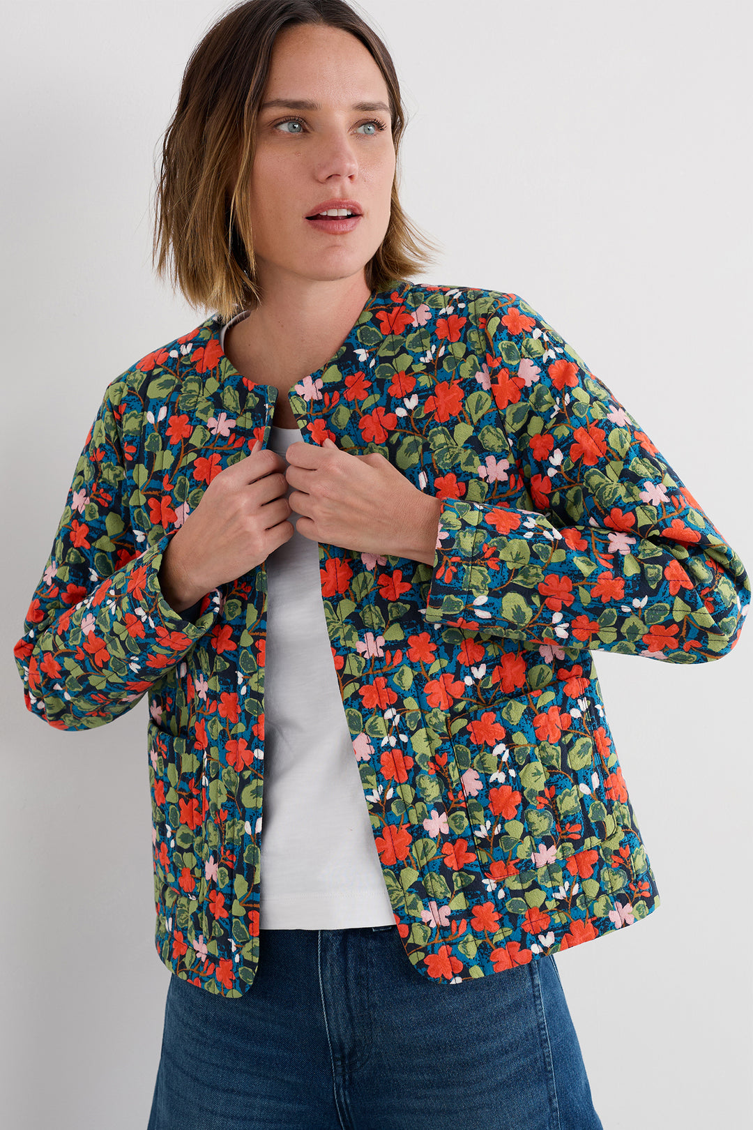 Woman wearing a colorful floral jacket on a white background