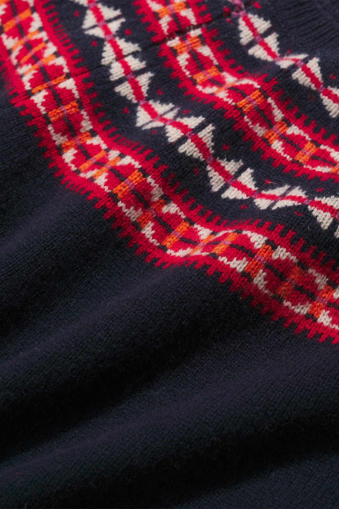Close-up of a dark blue sweater with red and white patterned collar