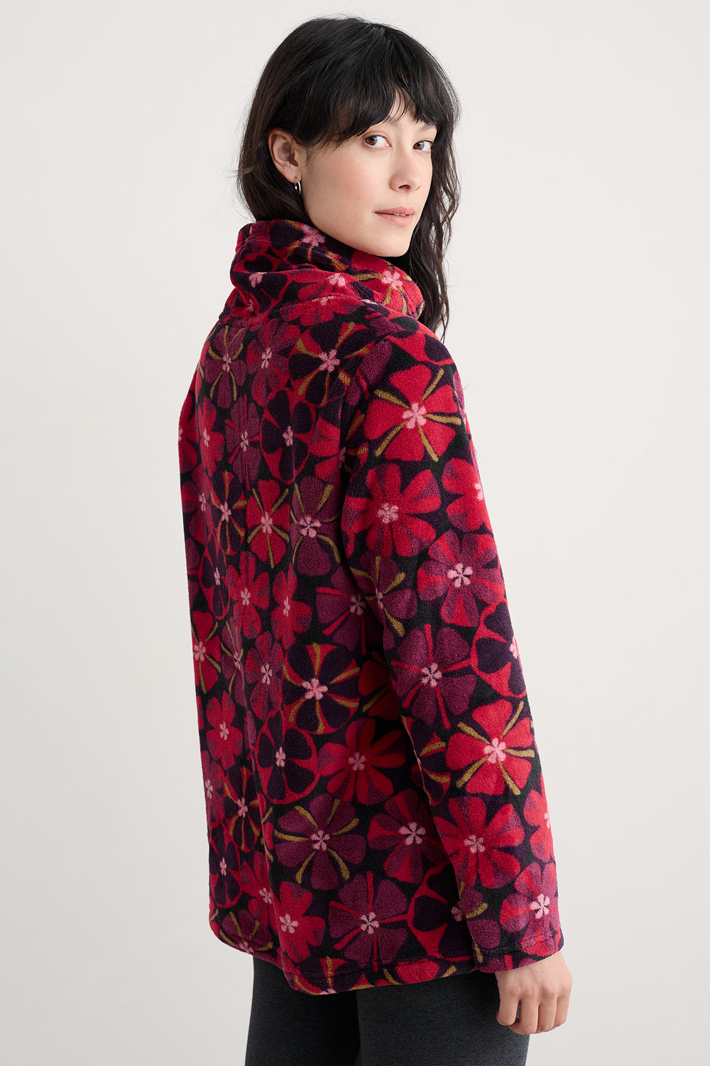 Woman wearing a red floral patterned coat on a white background
