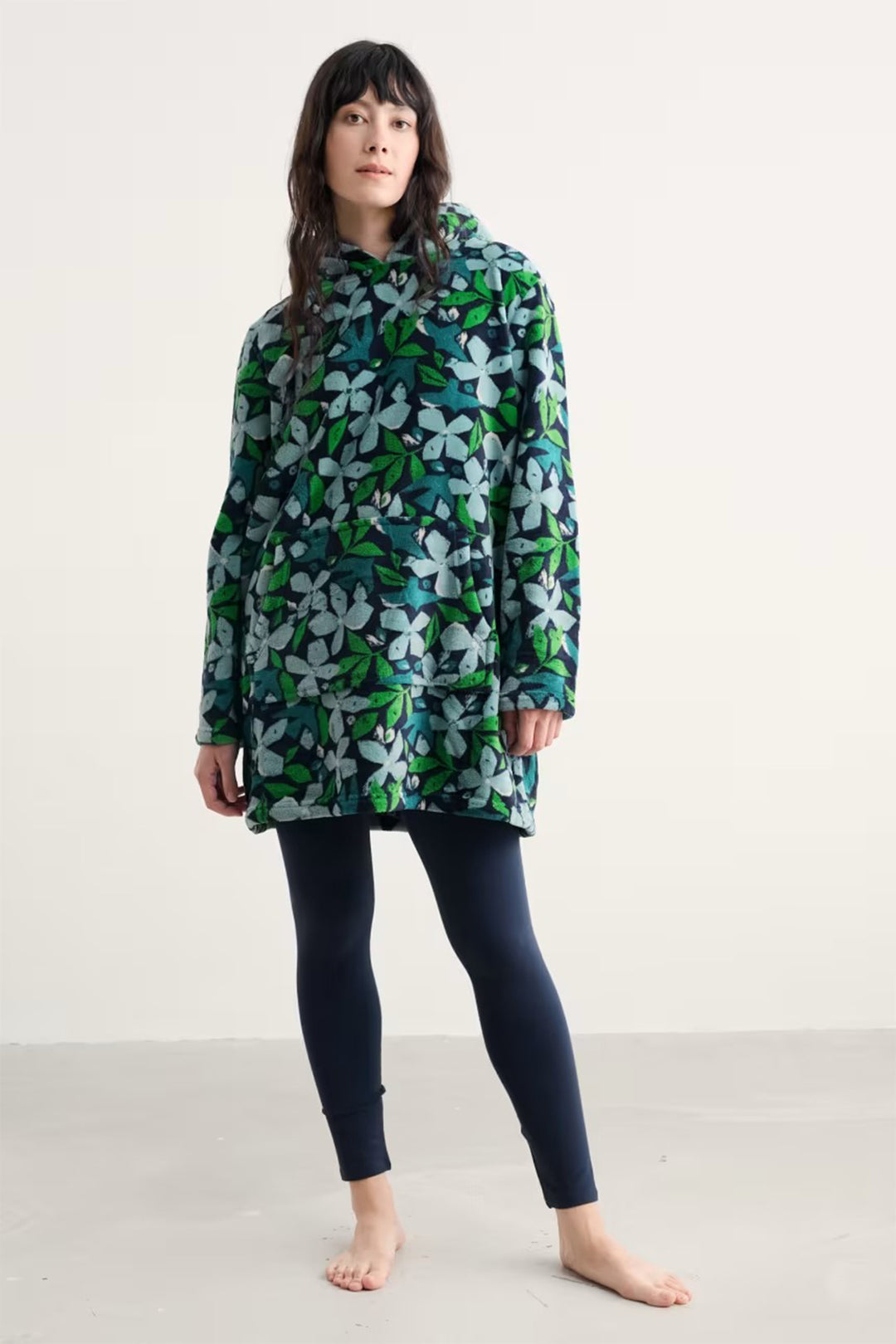 Person wearing a floral patterned raincoat on a plain background