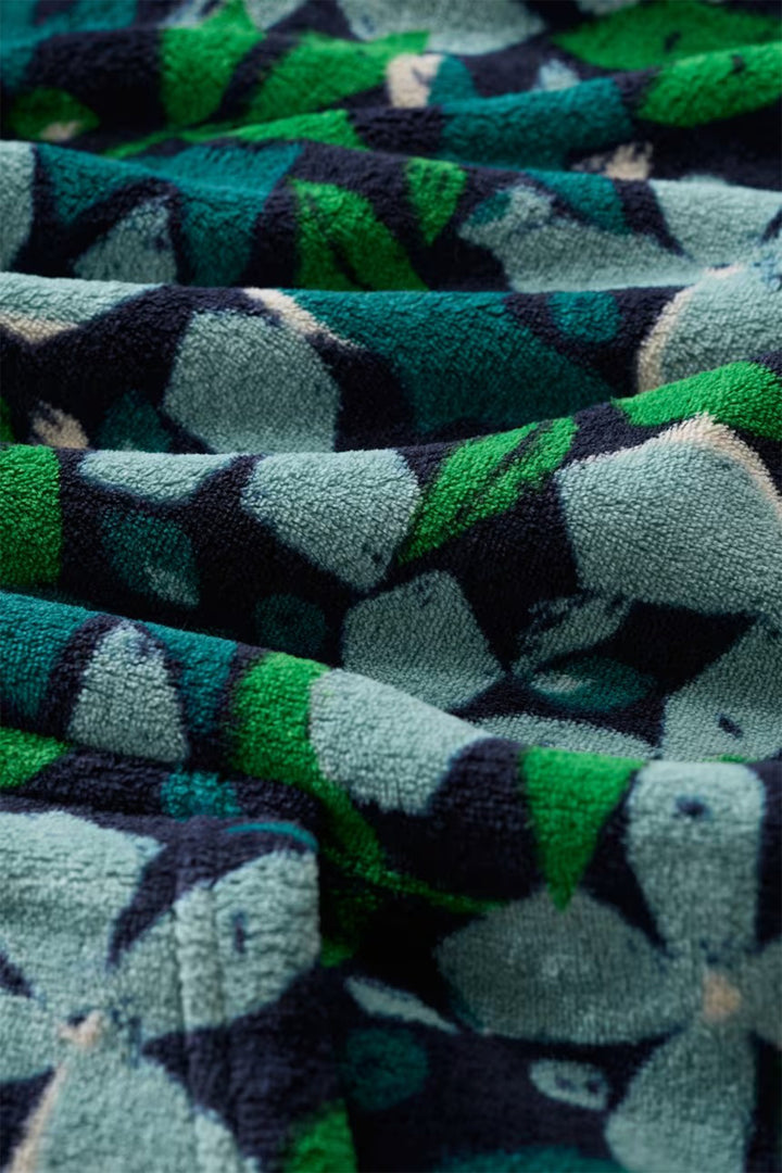 Close-up of patterned fabric with green, black, and gray colors.