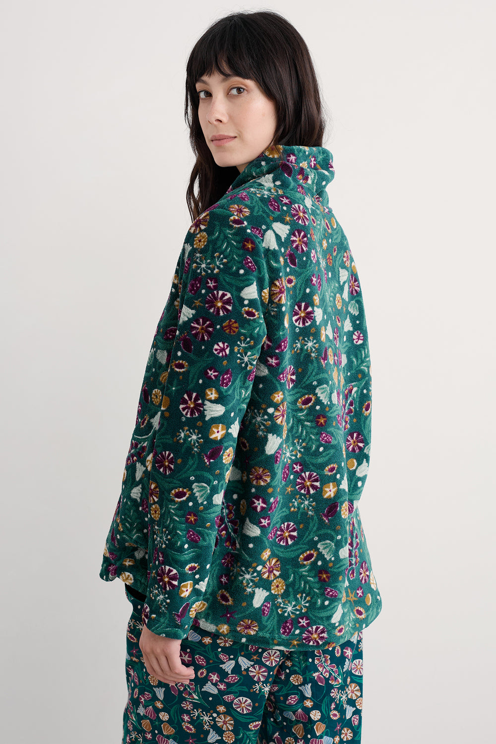 Person wearing a teal floral patterned outfit on a white background