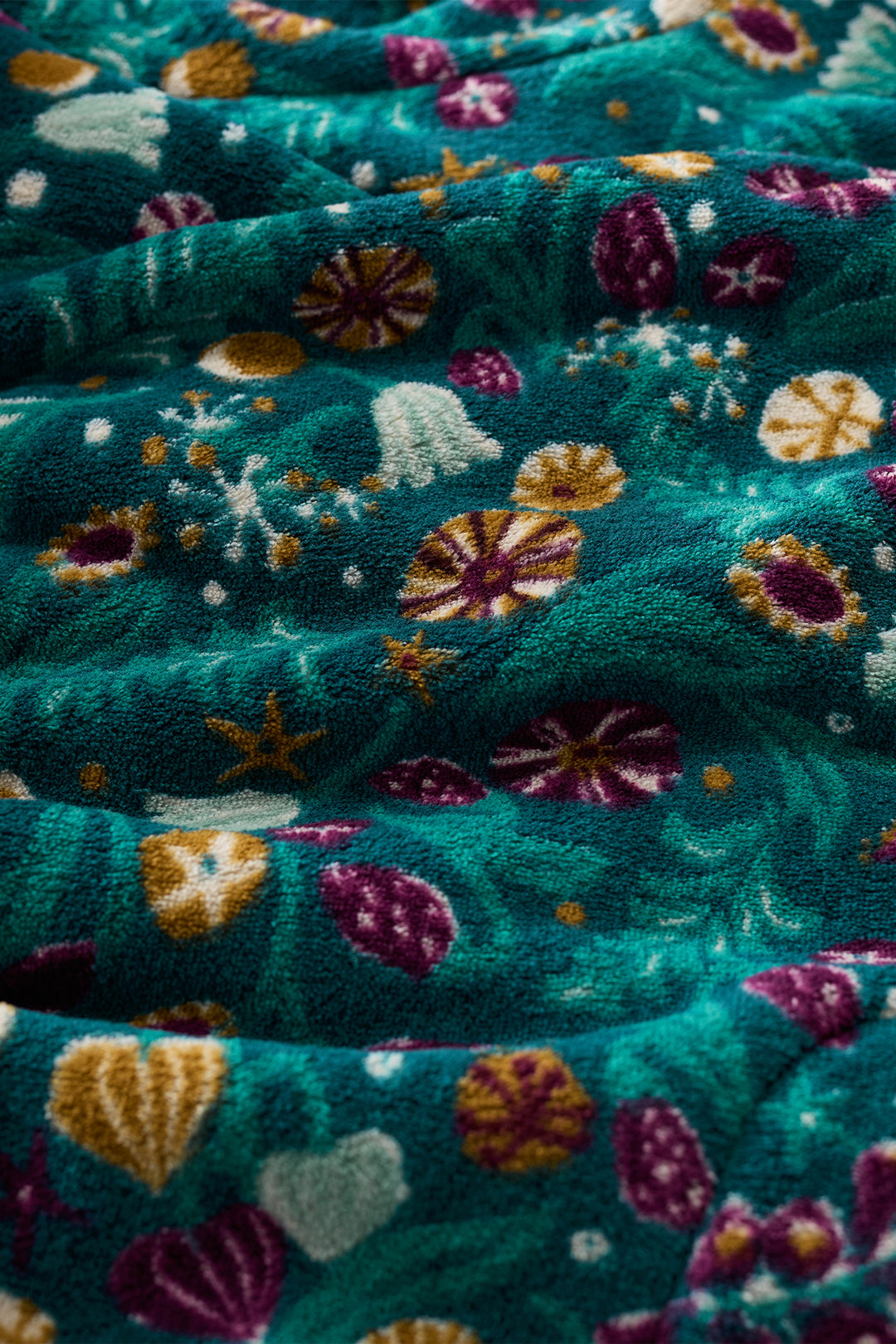 Close-up of teal fabric with colorful floral patterns