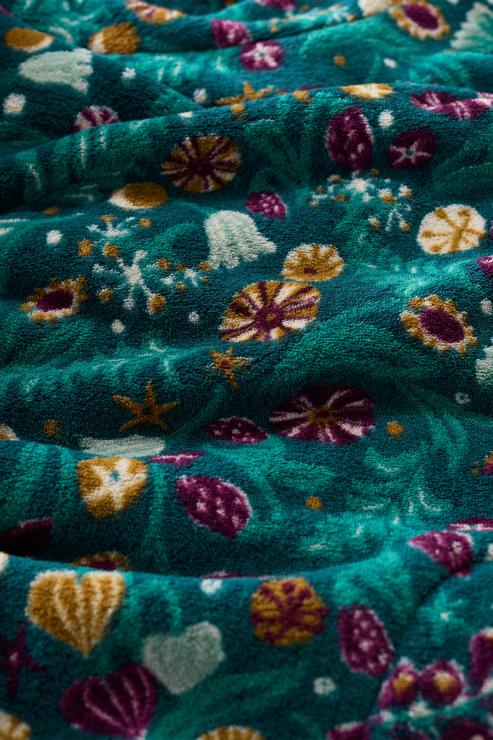 Close-up of teal fabric with colorful floral patterns