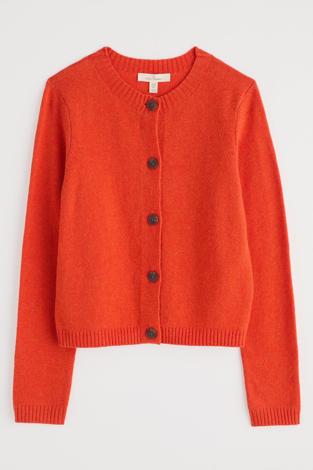 Orange cardigan with black buttons on a light gray background