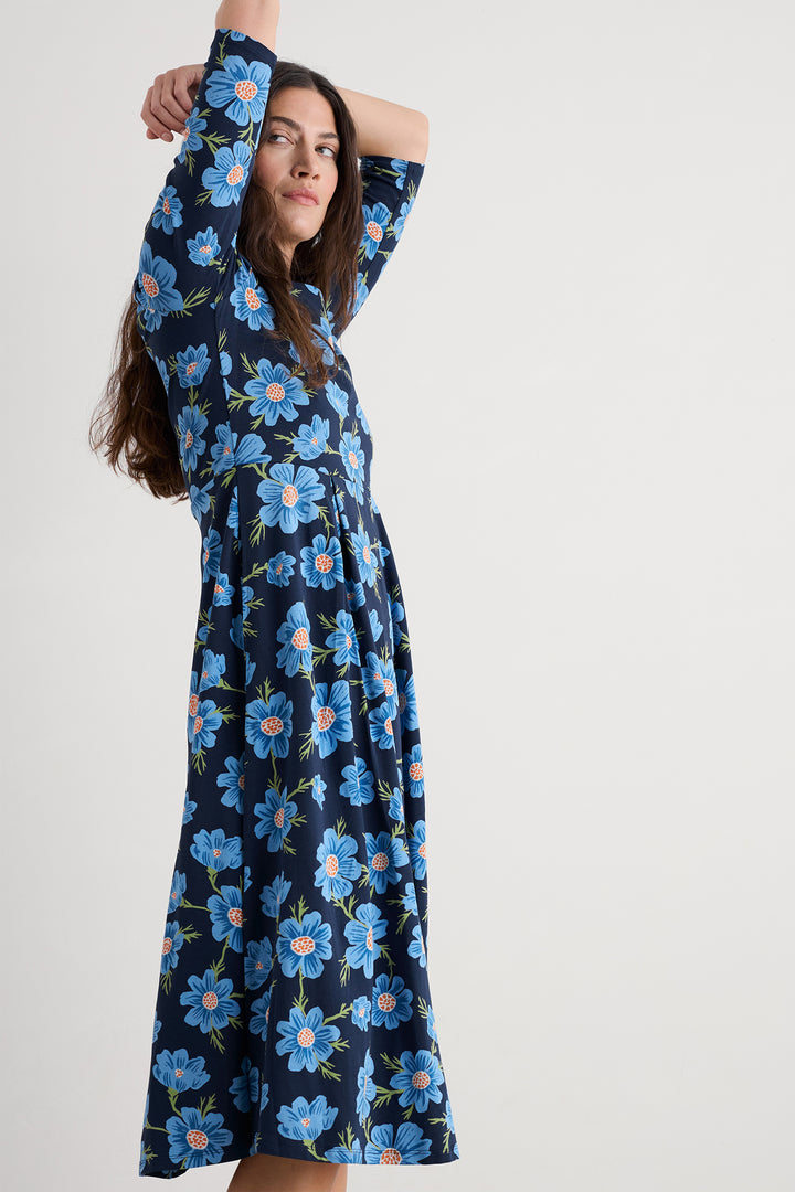 Woman wearing a blue floral dress against a white background