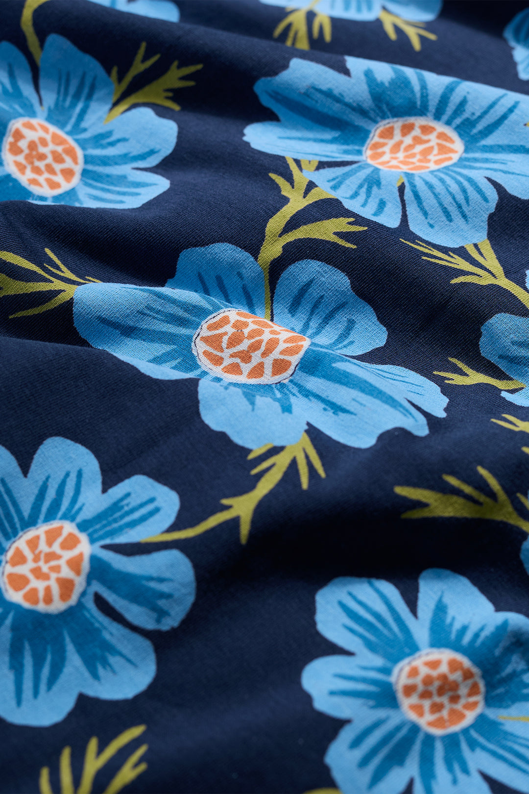 Navy blue fabric with large blue flowers and orange centers