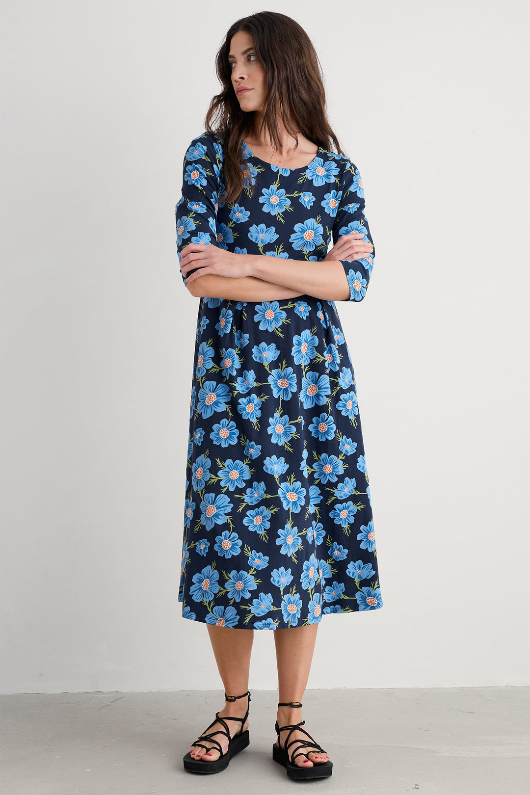 Woman wearing a blue floral dress against a white background