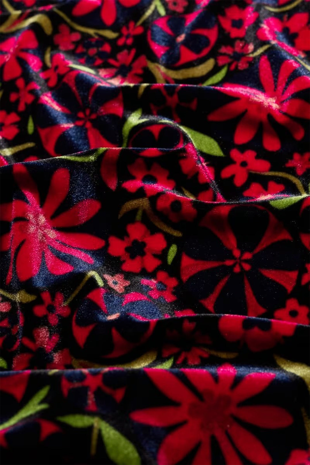 Close-up of fabric with red floral pattern on black background