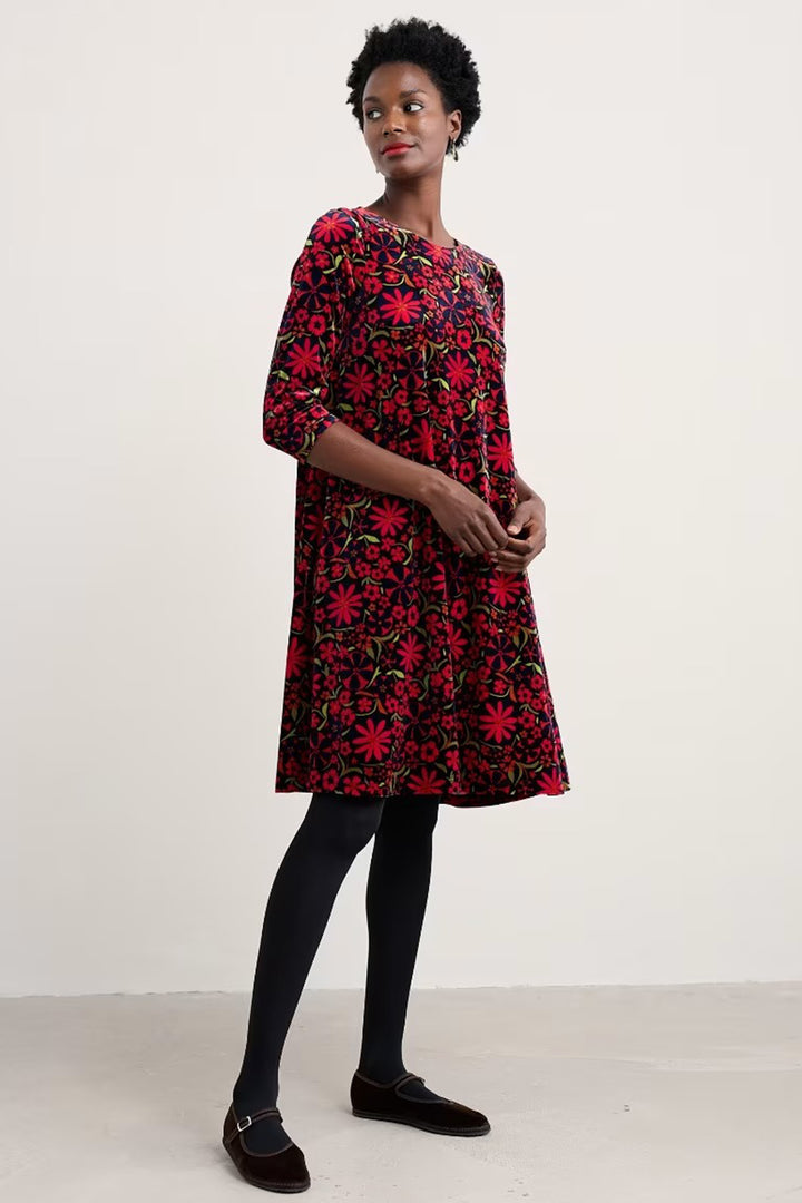 Woman wearing a red floral dress on a white background