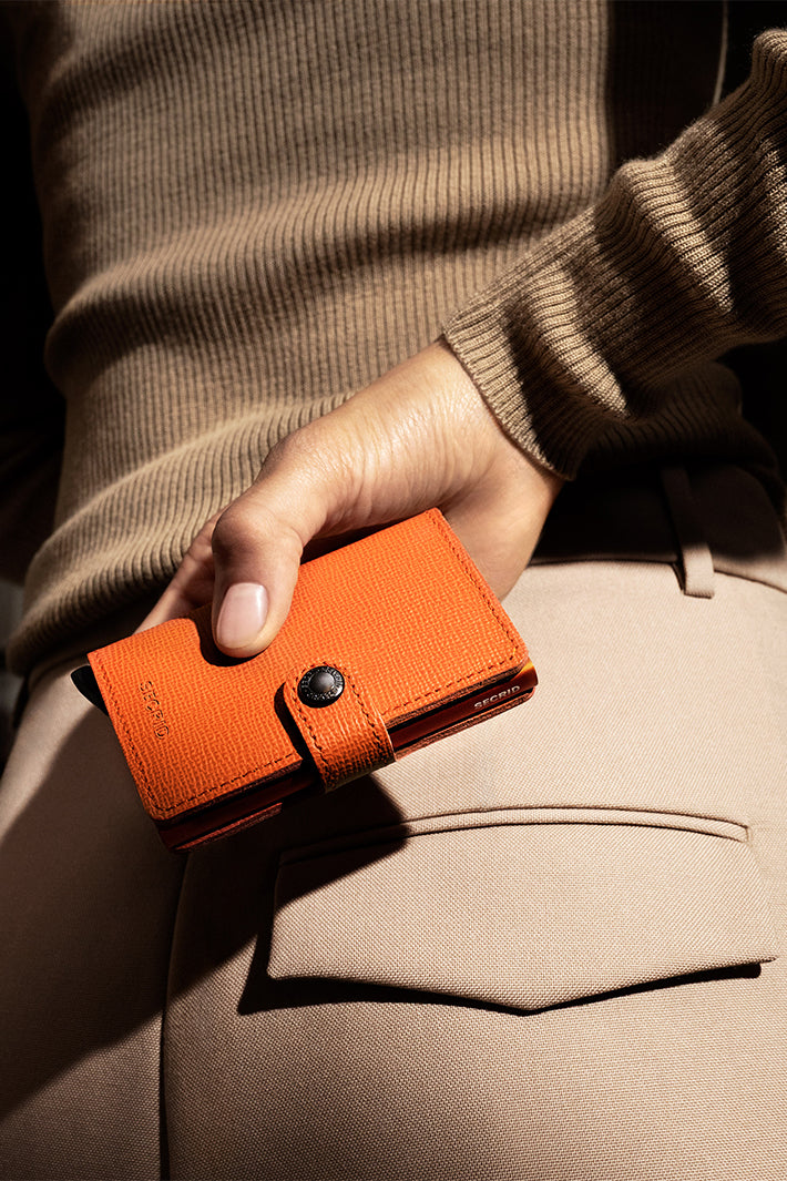 Secrid Miniwallet Crisple Pumpkin Orange, held in hand