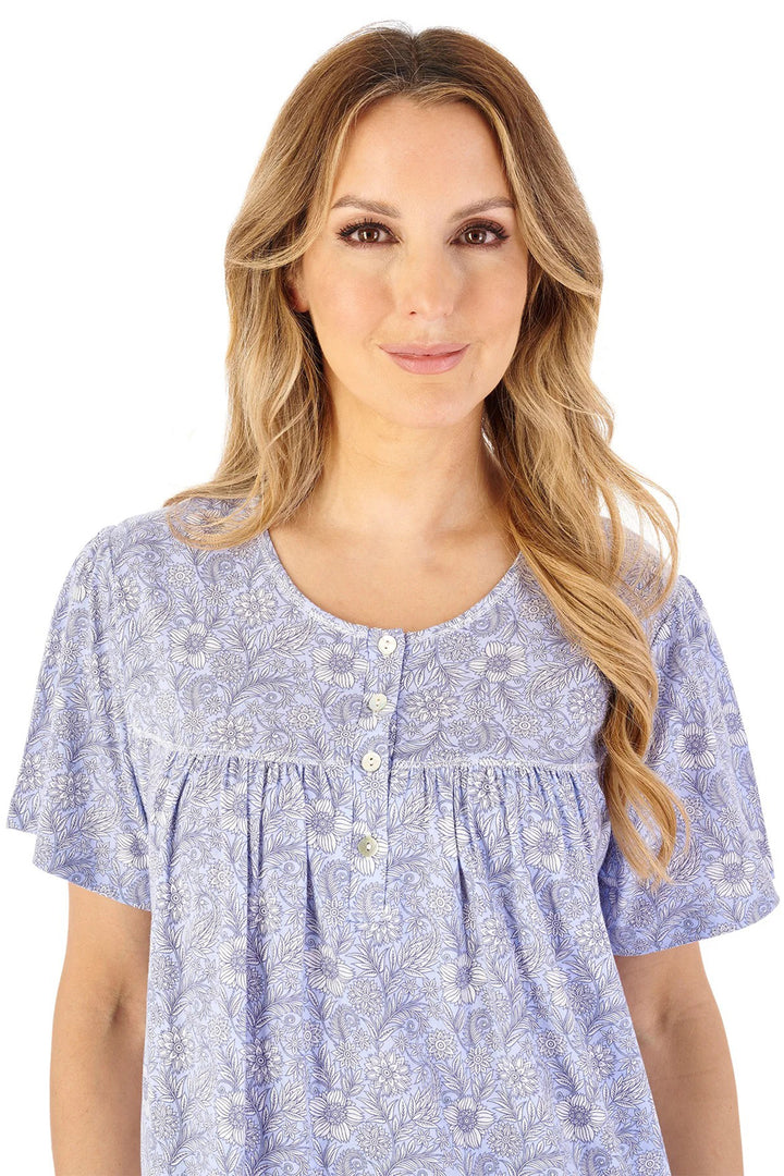 Woman wearing a blue floral patterned blouse on a white background