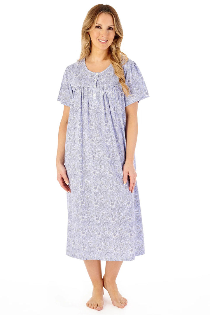 Woman wearing a long floral nightgown on a white background
