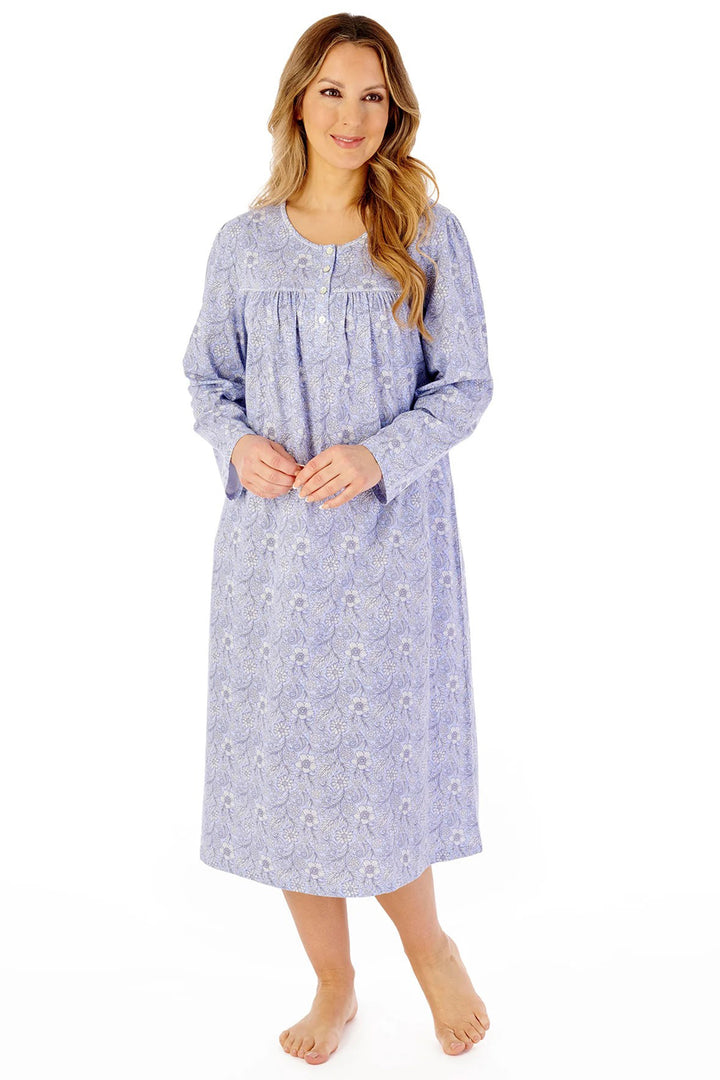 Woman wearing a long-sleeve nightgown with a floral pattern on a white background