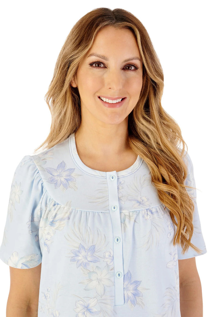 Woman wearing a light blue floral blouse on a white background