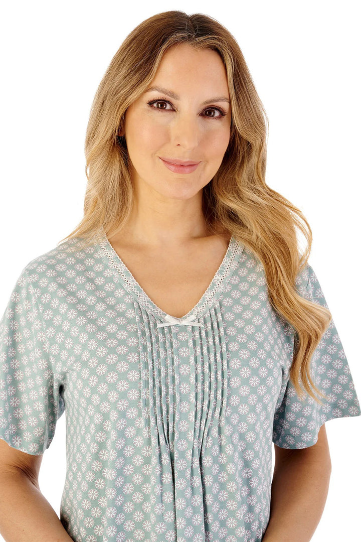 Woman wearing a light blue patterned blouse on a white background