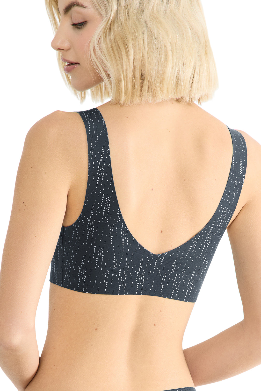 Person wearing a black bralette on a white background