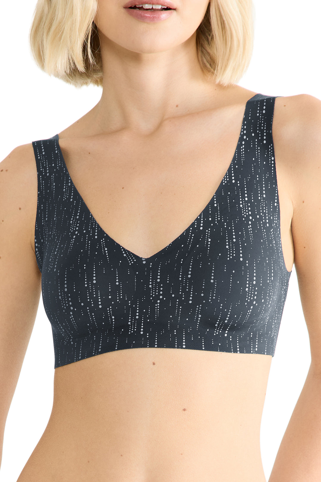 Woman wearing a black bralette with a subtle pattern on a white background