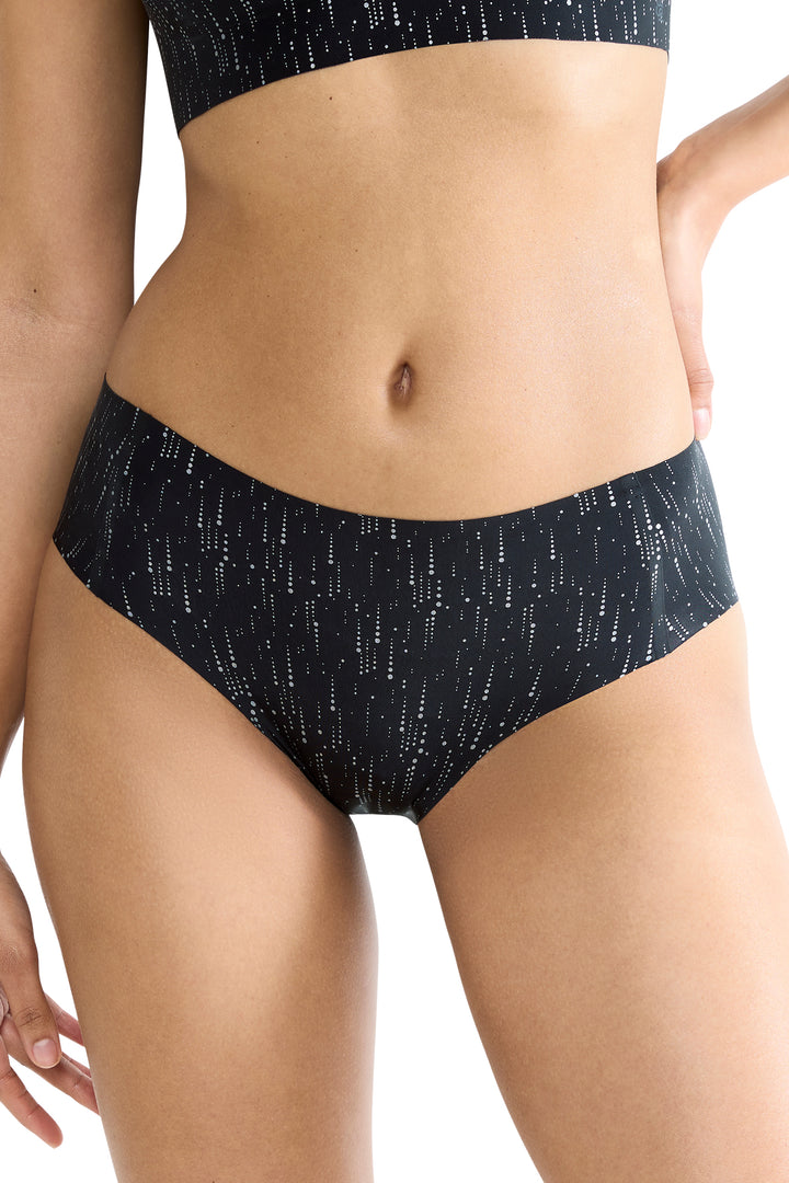 Person wearing black patterned underwear on a white background