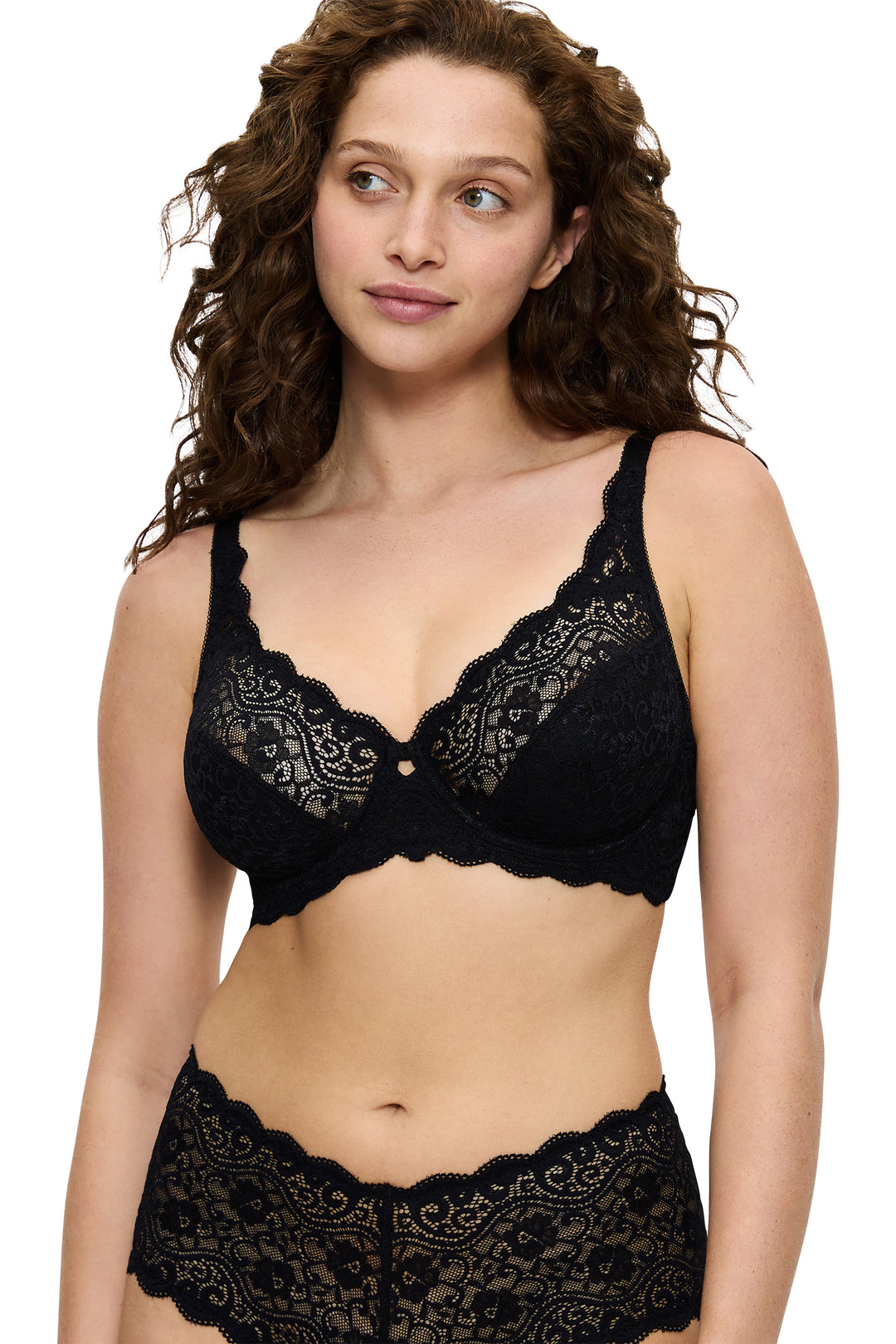 Woman wearing a black lace bra and panties set on a white background