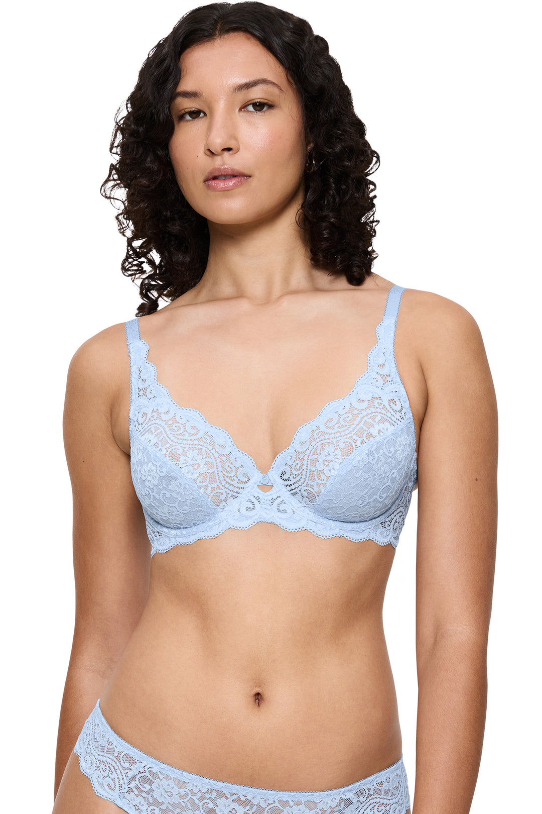 Woman wearing a light blue lace bra and panties set on a white background