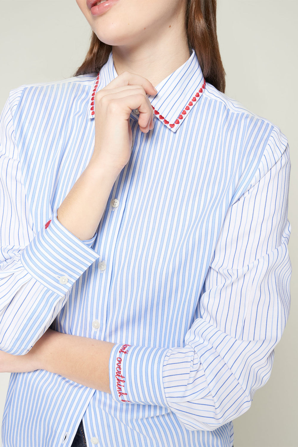 Person wearing a blue and white striped shirt with red accents