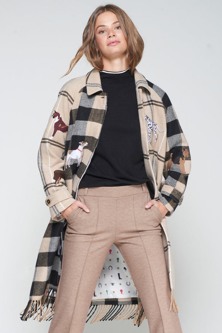 Person wearing a long plaid coat with animal prints on a plain background