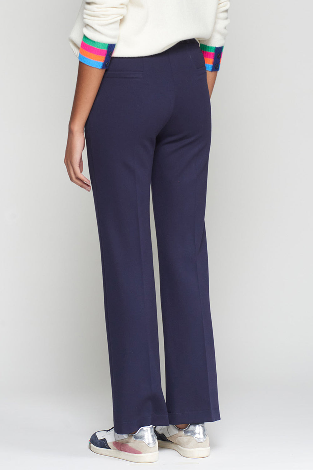 Navy blue pants worn by a person on a white background