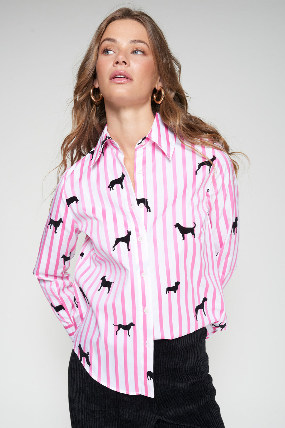 Woman wearing a pink striped shirt with black dog pattern on a white background