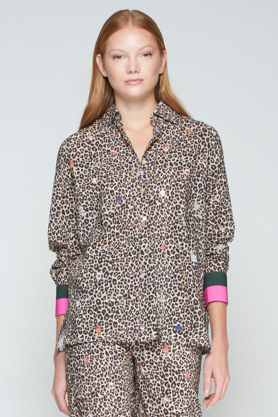 Person wearing a leopard print outfit with pink accents on a light gray background