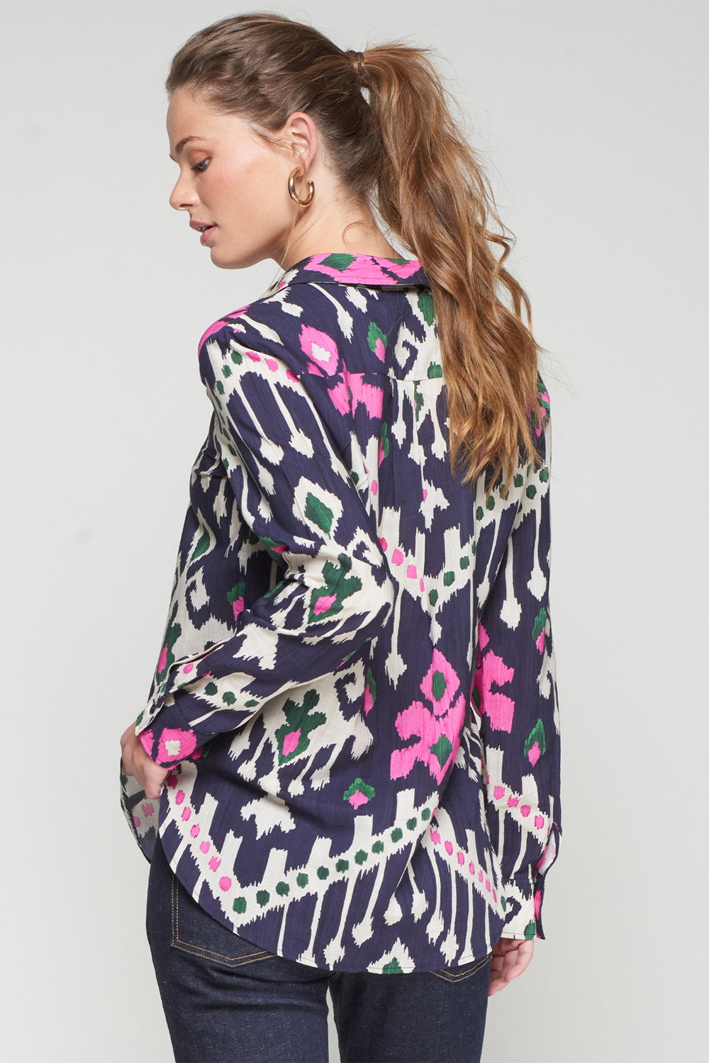 Woman wearing a patterned cardigan with a white background