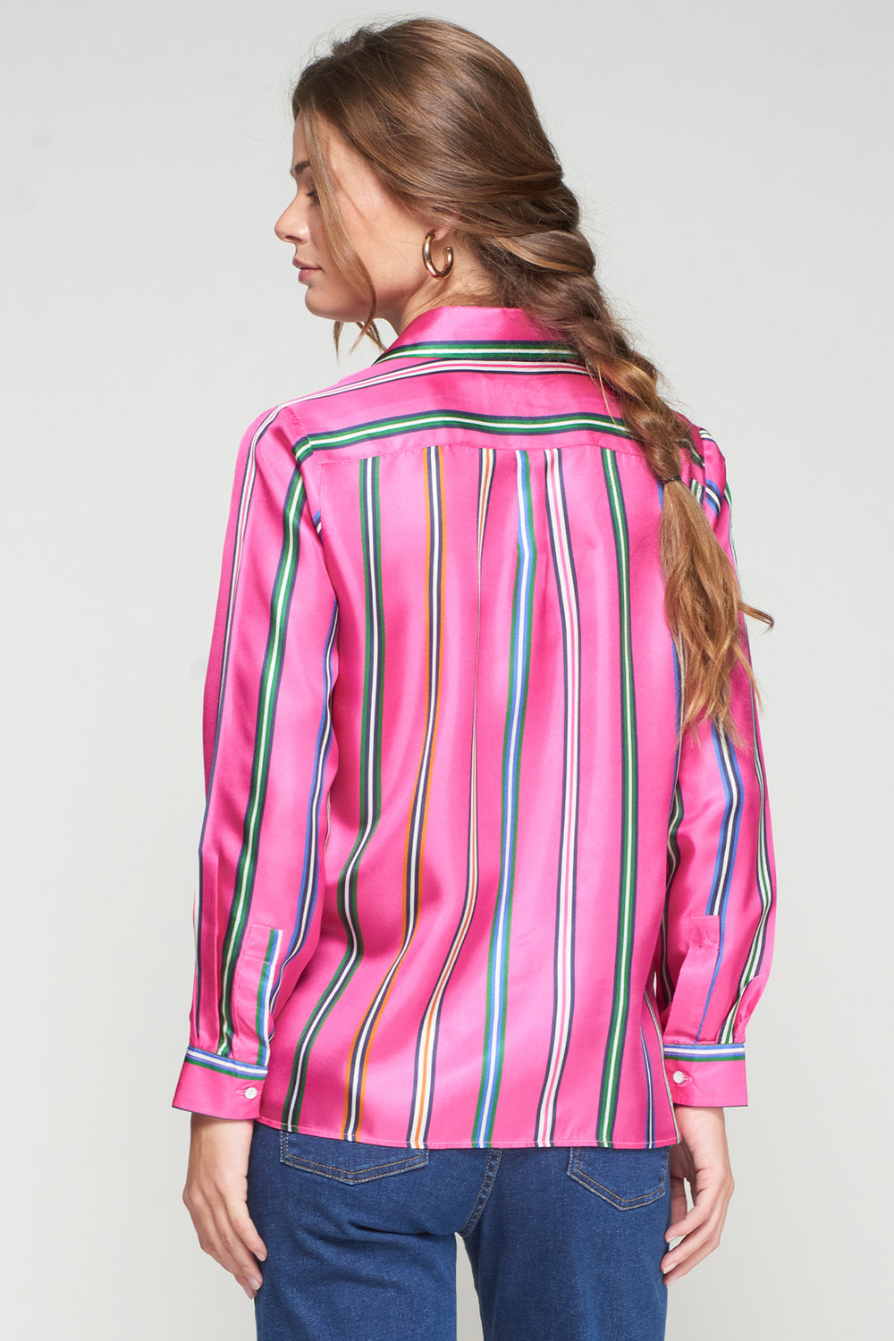 Woman wearing a pink striped shirt with a plain background