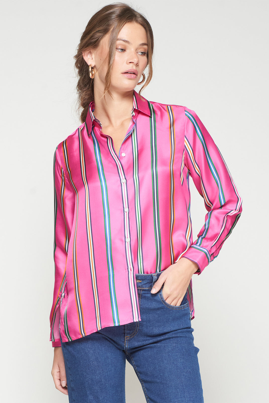 Woman wearing a pink striped shirt with a plain background