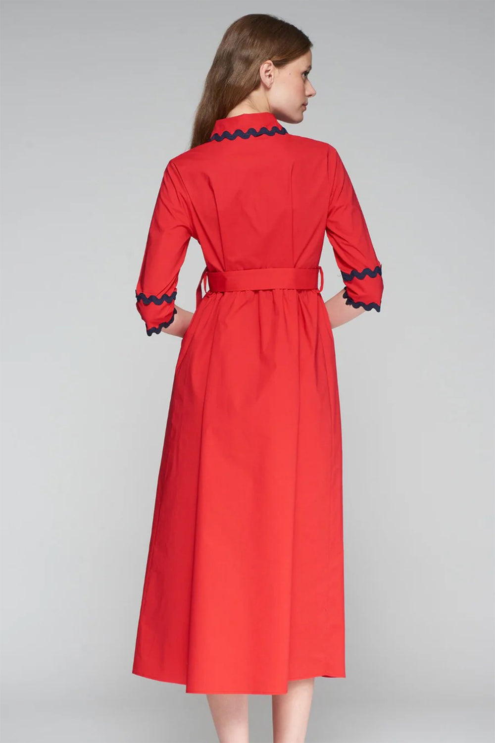 Red dress with black trim on a gray background