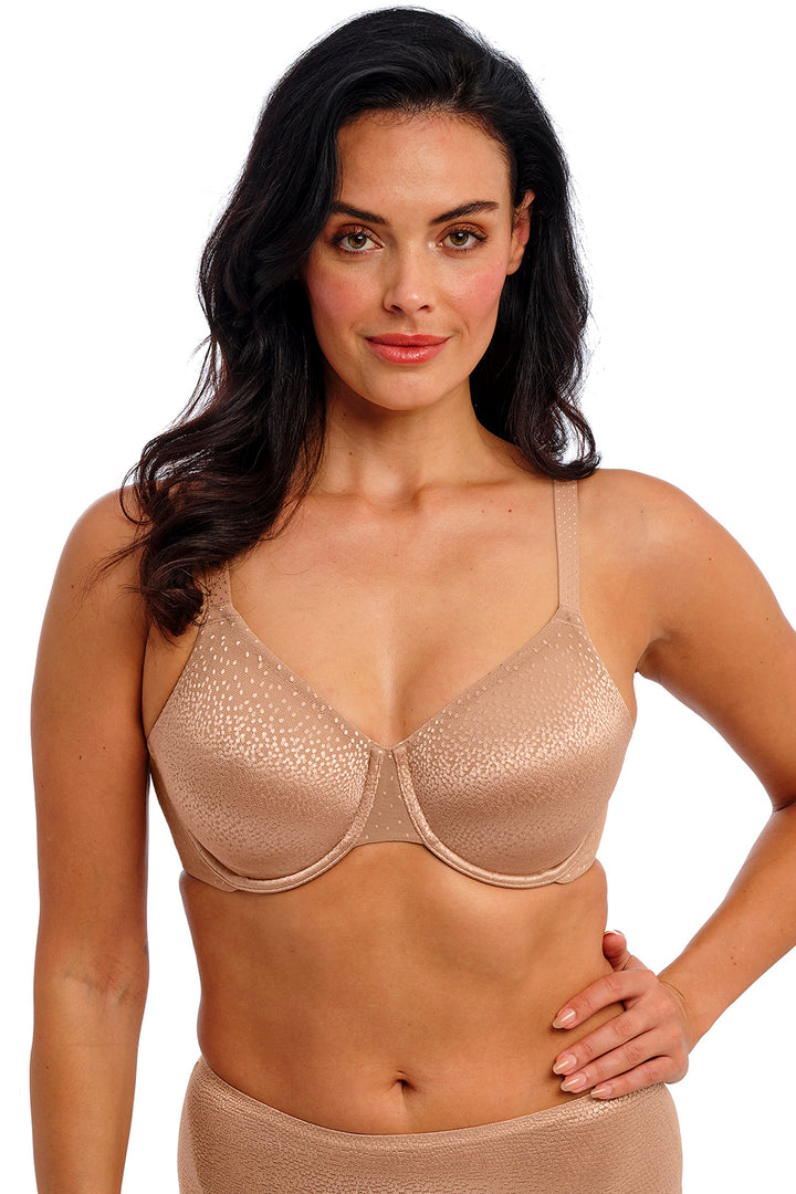 Woman wearing a beige bra and underwear set on a white background