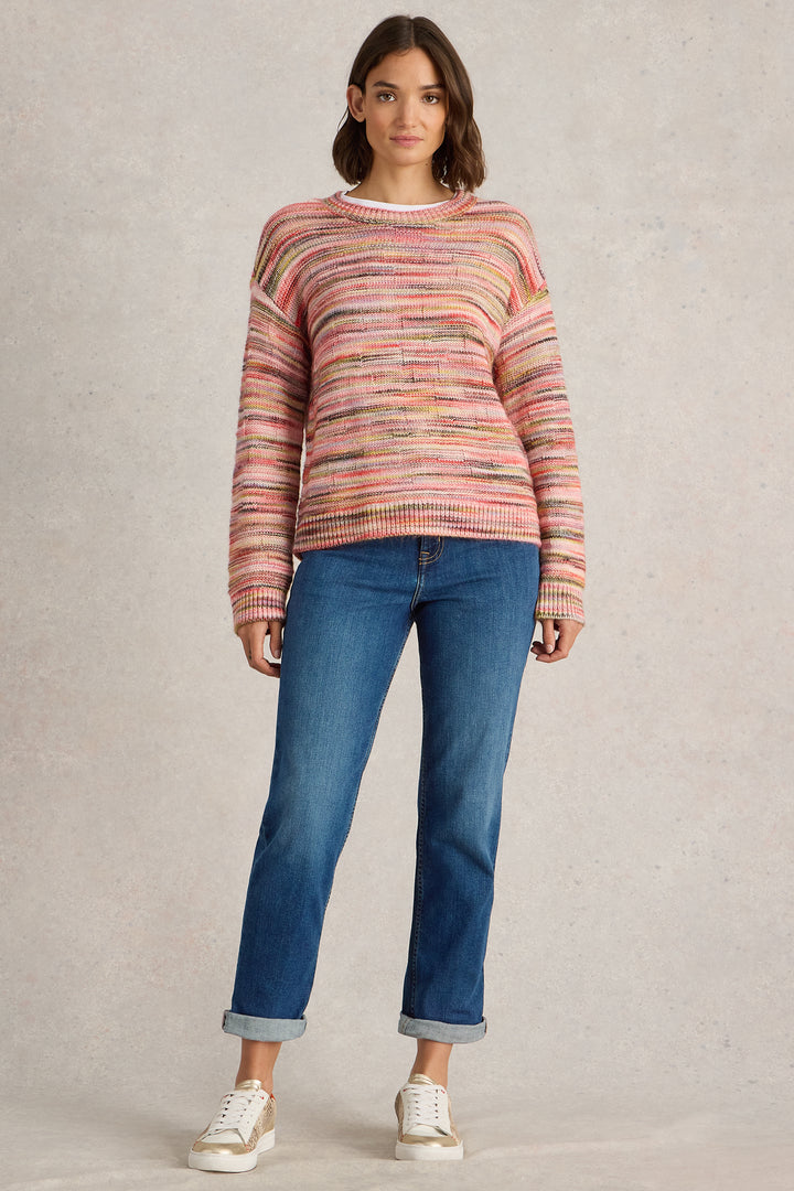 Woman wearing a striped sweater and blue jeans on a beige background