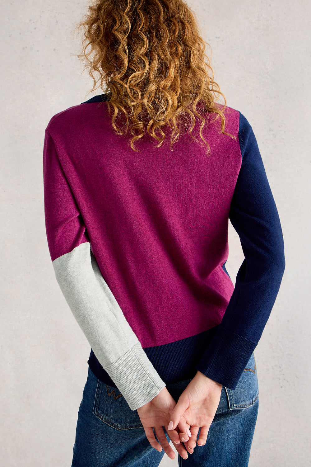 Person wearing a colorful sweater with a neutral background