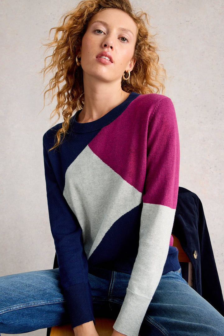 Woman wearing a colorful sweater with a neutral background