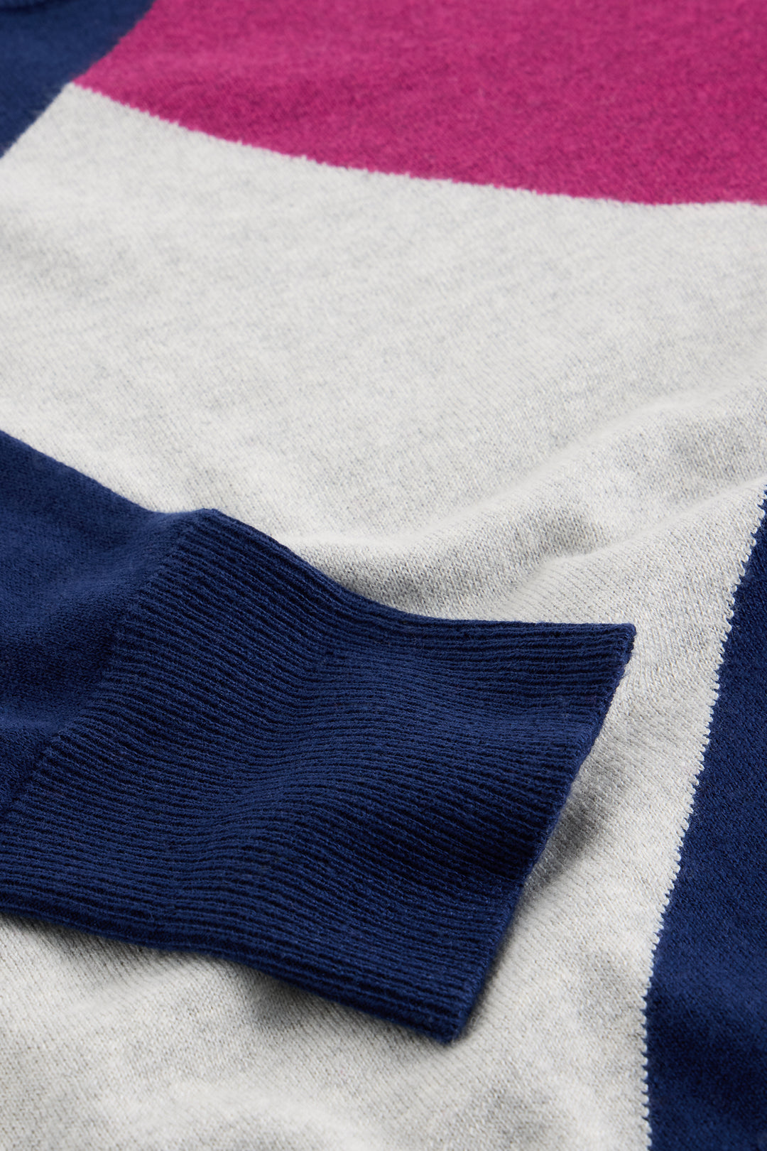 Close-up of a sweater with blue, gray, and pink color block pattern.