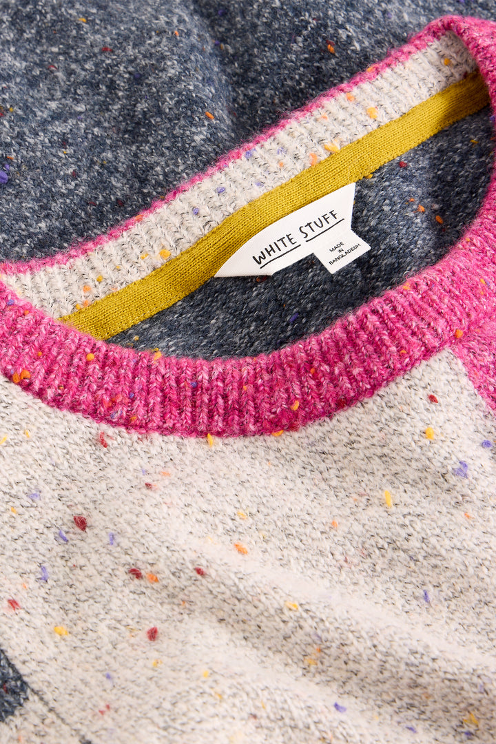 Close-up of a sweater with colorful speckles and a visible brand label.