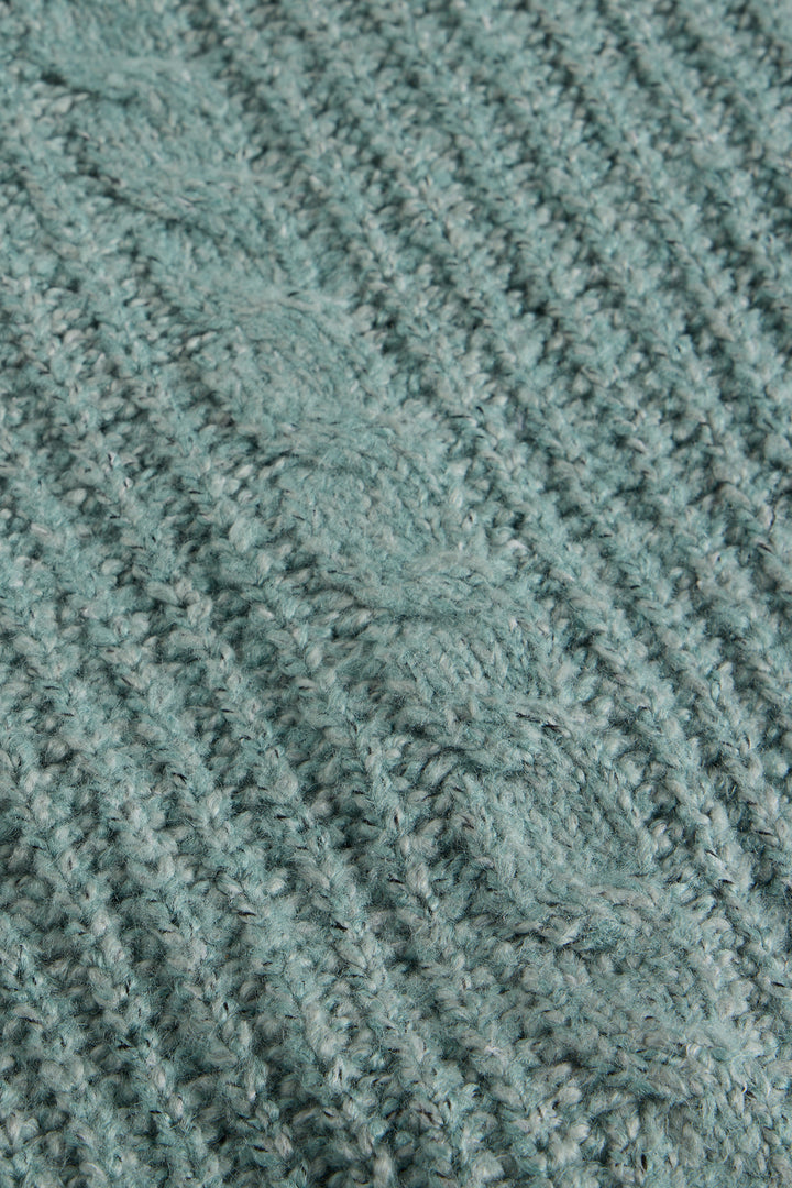 Close-up of a textured teal fabric with a cable knit pattern