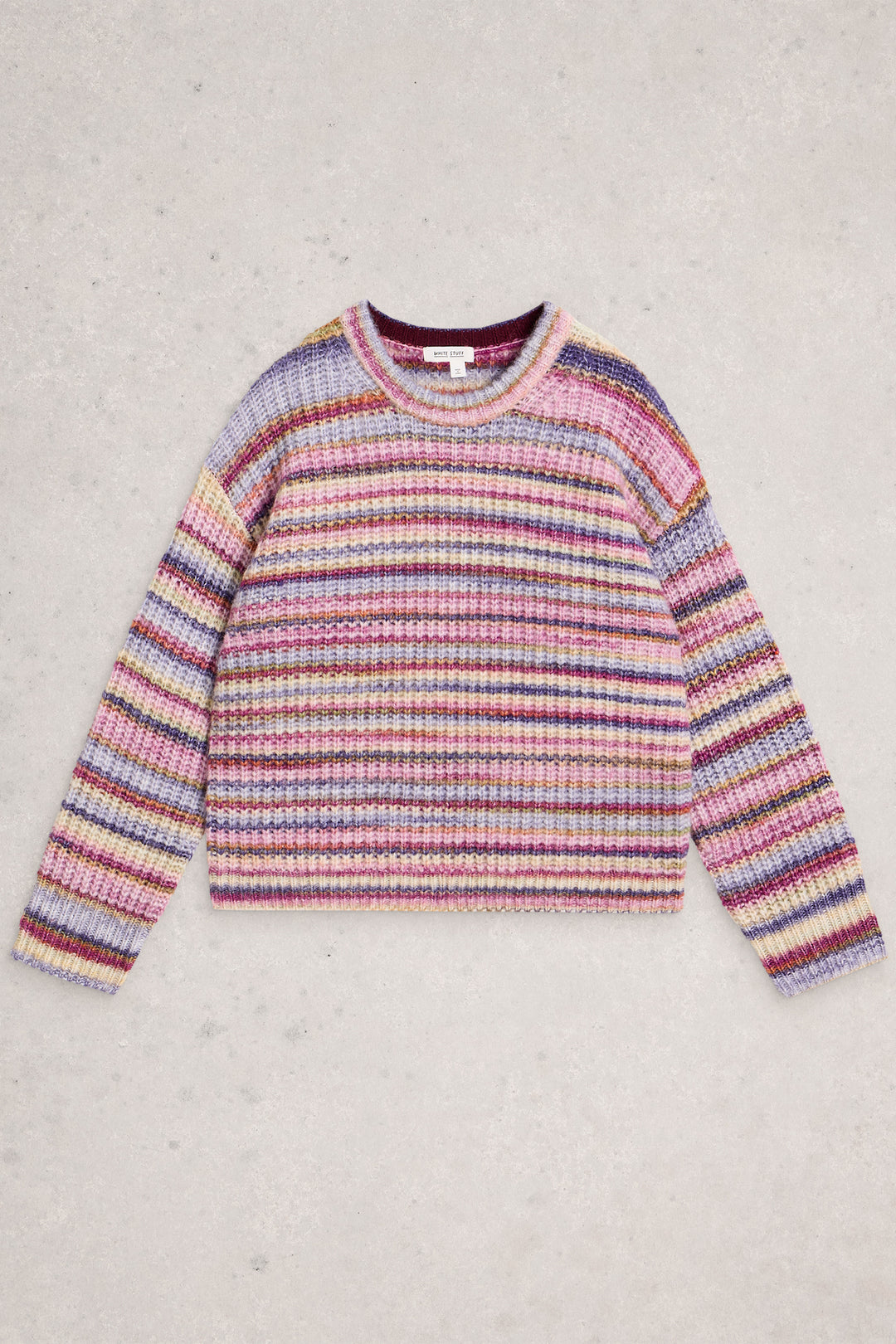 Multicolored striped sweater on a light gray background
