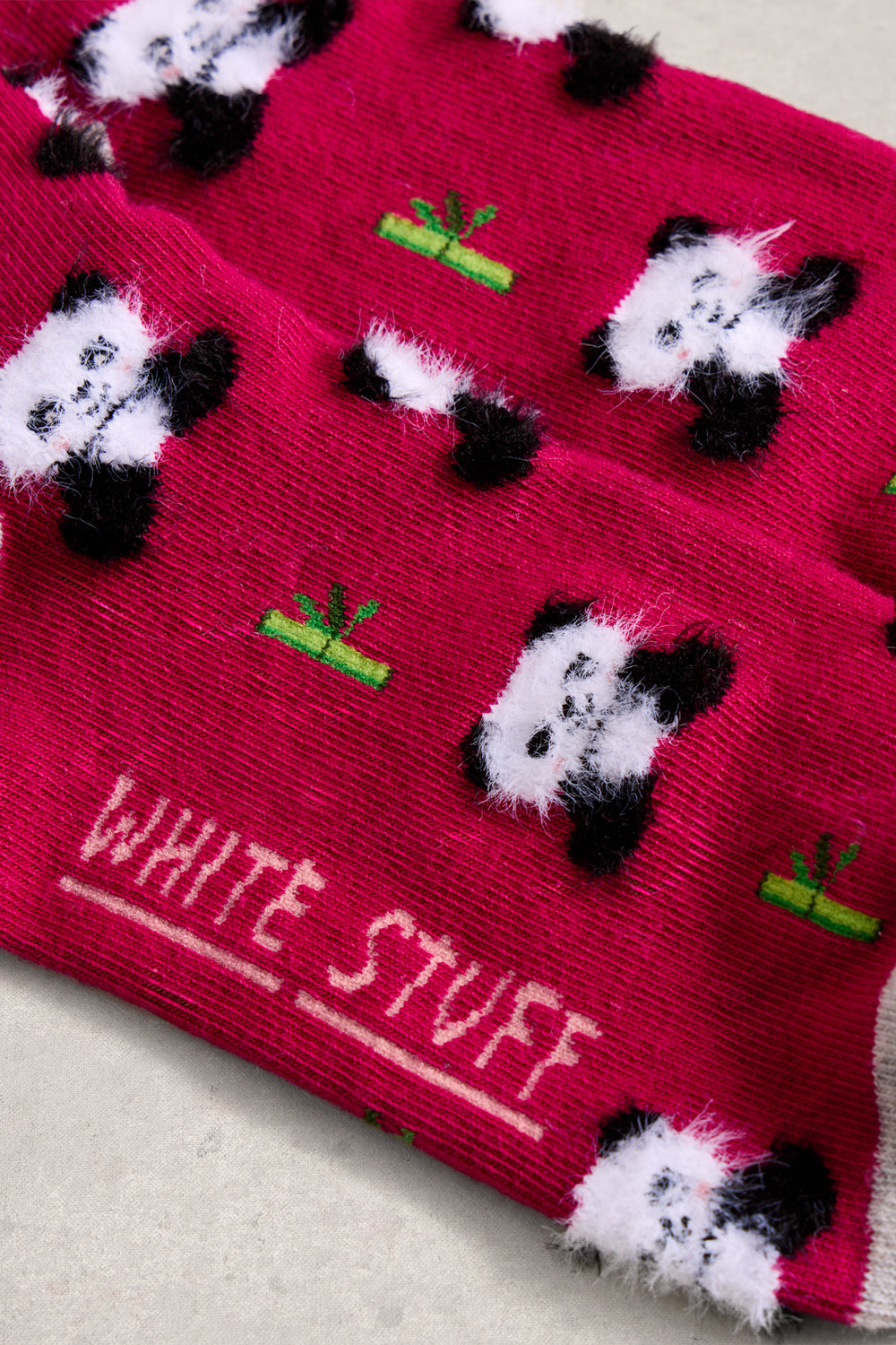 Pink socks with panda designs and 'White Stuff' branding on a light background