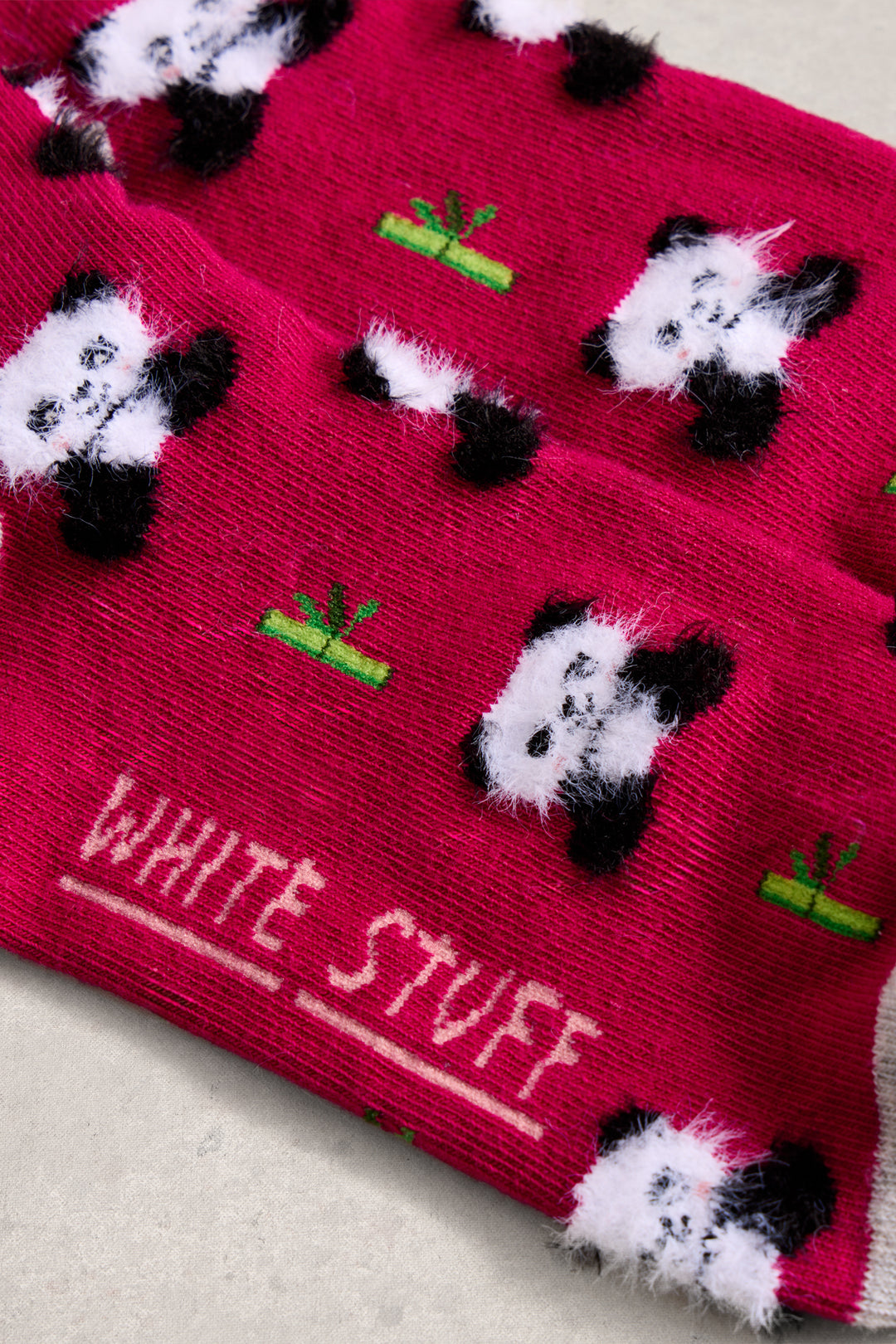 Pink socks with panda designs and 'White Stuff' branding on a light background